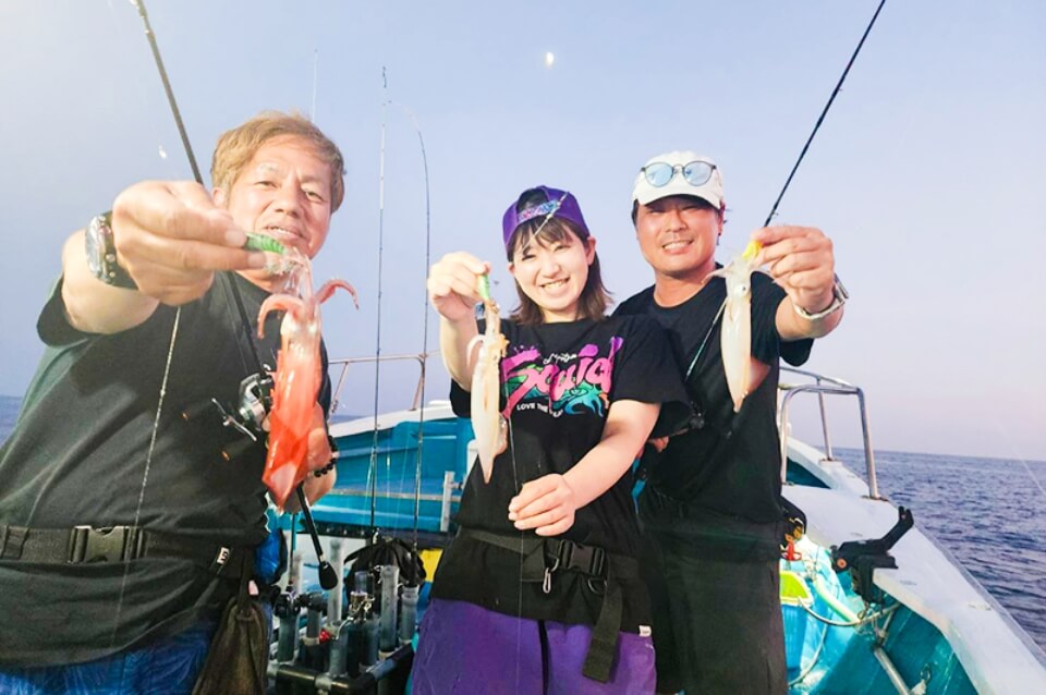 釣った魚をカメラに向ける3人組の様子